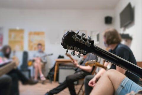 Busca representar a estudiantes participando en las ofertas musicales de la universidad o Instrumentos musicales listos para las ofertas musicales universitarias.